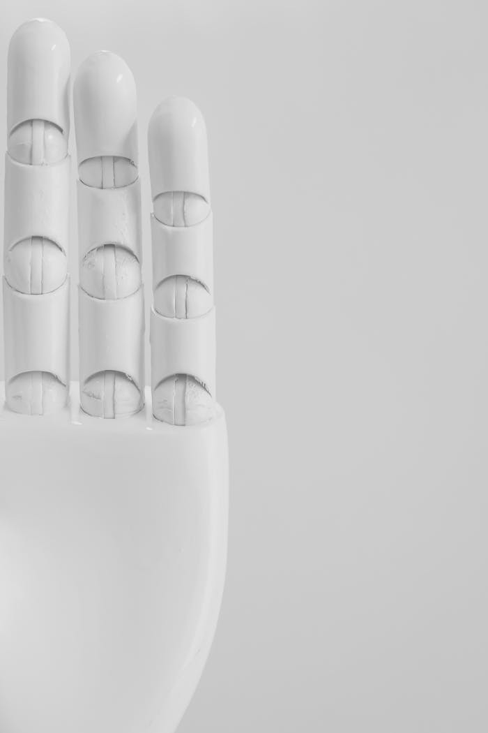 Close-up of a minimalist white robotic hand on a monochrome background.